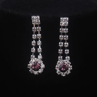 High end and elegant bridal accessories, including a necklace and a pair of earrings, set in blue, red, and purple. Bridal acces