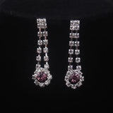 High end and elegant bridal accessories, including a necklace and a pair of earrings, set in blue, red, and purple. Bridal acces