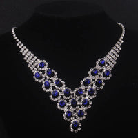 High end and elegant bridal accessories, including a necklace and a pair of earrings, set in blue, red, and purple. Bridal acces