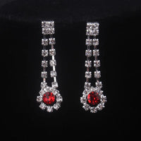 High end and elegant bridal accessories, including a necklace and a pair of earrings, set in blue, red, and purple. Bridal acces