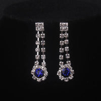 High end and elegant bridal accessories, including a necklace and a pair of earrings, set in blue, red, and purple. Bridal acces