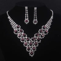 High end and elegant bridal accessories, including a necklace and a pair of earrings, set in blue, red, and purple. Bridal acces